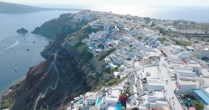 Drone soars over Santorini's sunny, luxury-laden vistas.