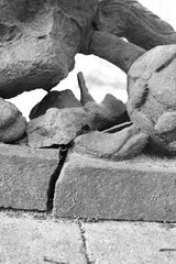 Detail of a broken sandstone statue in black and white.