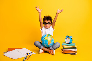 Full length photo of excited funky little boy dressed white t-shirt studying geography isolated yellow color background