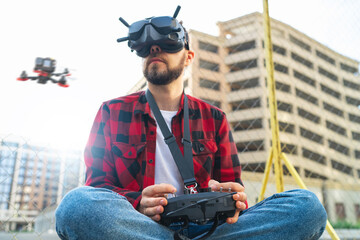 Man using goggles antenna remote controller for operating fpv copter drone for aerial photography...