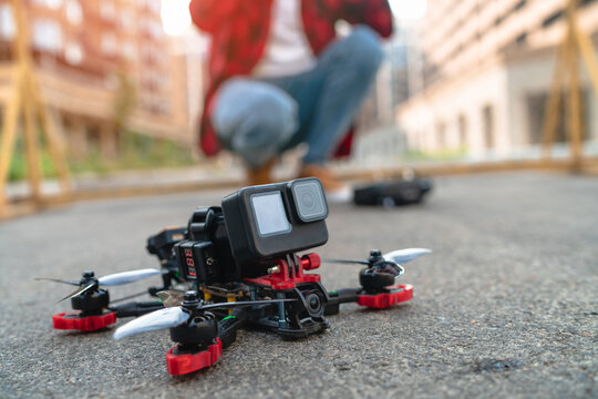 Cropped shot of a proffessional fpv pilot man landing his drone on a street road