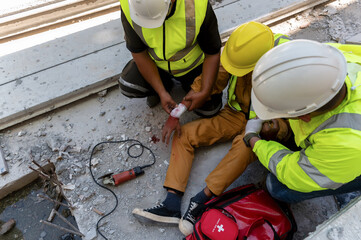 First aid team support to builder worker after hand injury bleeding, accident at work, Using...