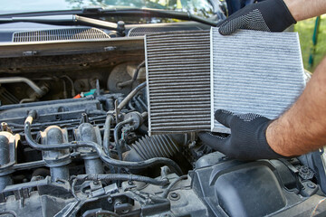 The old clogged air filter is replaced with a new one. Car repair and maintenance.
