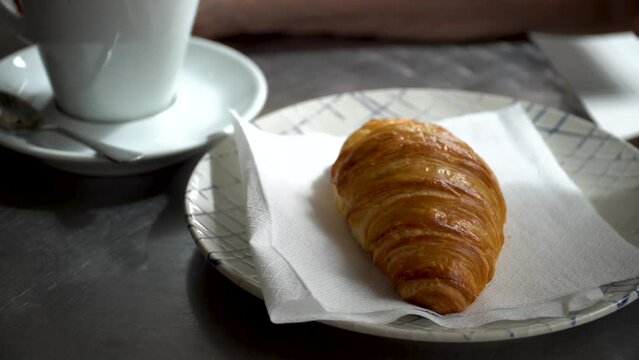 Latte and a puff pastry bun on the table, breakfast in the cafeteria