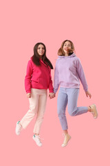 Obraz premium Female friends jumping on pink background