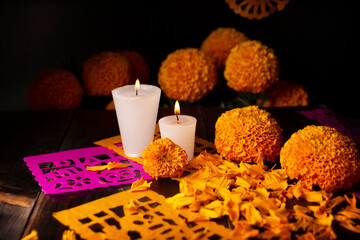 Candles with Cempasuchil orange flowers or Marigold. (Tagetes erecta) and Papel Picado. Decoration traditionally used in altars for the celebration of the day of the dead in Mexico
