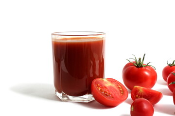 On a white background is a glass of tomato juice with tomatoes and herbs.