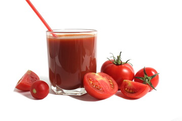  On a white background is a glass of tomato juice with tomatoes and herbs.