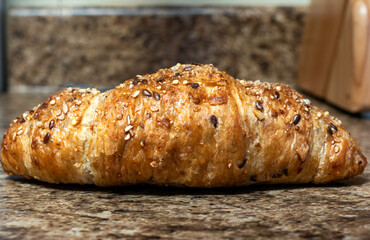 Freshly baked wheat croissant with seeds