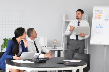Fototapeta premium Male business consultant giving presentation to his colleagues in office