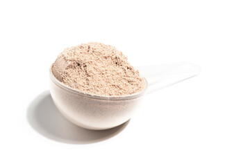 Chocolate whey protein powder in a plastic measuring spoon, isolated on white background
