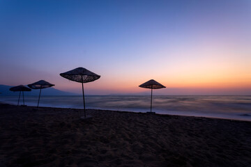 An empty beach landscape photographed with a long exposure technique at sunset.  