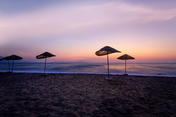 An empty beach landscape photographed with a long exposure technique at sunset.  