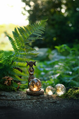 wiccan Goddess ritual figurine with crystal balls in forest, abstract natural background. esoteric...