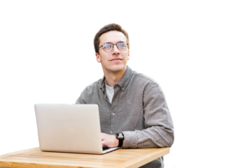 A male freelancer works productively remotely online, uses a laptop and a computer, a workplace in the office.