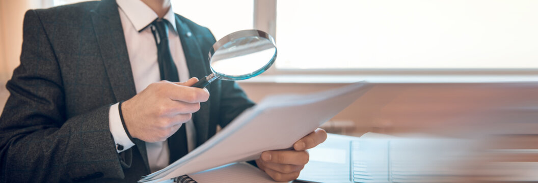 man hand magnifier and document