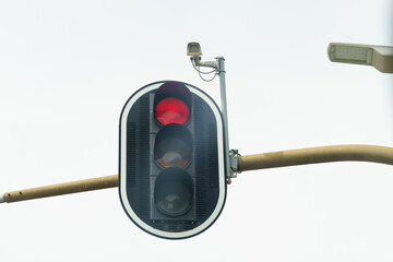 View of a traffic light and a traffic camera that captures the passage of a red traffic light.