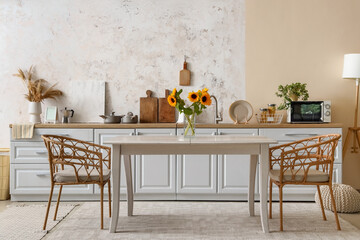 Interior of modern kitchen with white counters and dining table