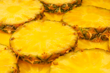 Pineapple juicy yellow slices as a background.