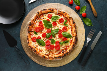 Wooden board with tasty pizza Margarita on black background
