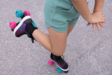 Legs of a little girl riding bright roller skates