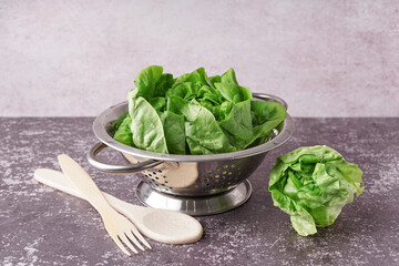 Colander with fresh Boston lettuce on table