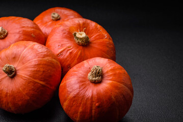 Beautiful fresh round pumpkins in orange color on a dark concrete background