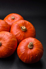 Beautiful fresh round pumpkins in orange color on a dark concrete background