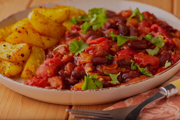 Mexican mixed bean chilli with oven baked chips.
