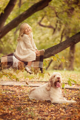 Little girl with white hair with dogs in the park in autumn