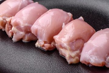 Fresh raw chicken thigh fillets with salt, spices and herbs