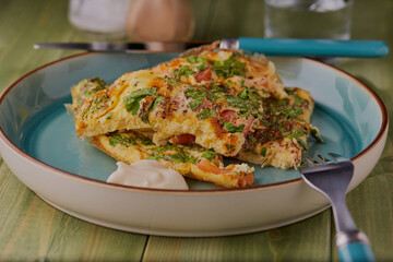 Slices of onion and tomato frittata stacked on top of each other with a spoonful  of mayonnaise.