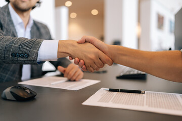 Close-up hands of unrecognizable business people handshaking after negotiation for business deal...