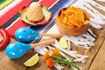 Poncho with food and Mexican symbols for Independence Day on wooden background, closeup