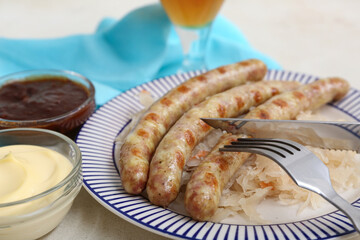 Plate with tasty Bavarian sausages, sauces and sauerkraut on white background. Oktoberfest celebration