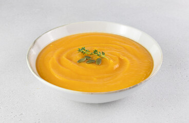 Pumpkin or carrot soup with a silky texture of pumpkin seeds on a white background. Top view.