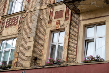Two white Windows on the facade of the old damaged brick building