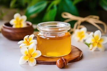 Glass jar of golden honey closeup with flowers