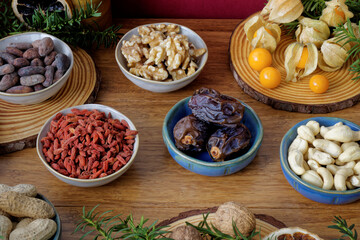 Assortment of healthy snacks: fruits and nuts on winter decorated table.