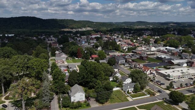 A wide slow forward aerial establishing shot of the small town of Zelienople, Pennsylvania in Butler County.  	