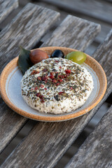 French fresh white soft goat cheeses with topping made with herbs, paprika, indian curry,  chives and dried tomatoes