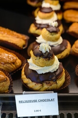 Assortment of french fresh baked sweet pastry with chocolate in confectionery shop in Paris, english translation is religious chocolate cake