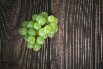 organic green grapes on a dark wooden base.