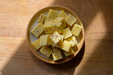 Cheese collection, matured yellow cow cheese cubes with mustard seeds from Belgium
