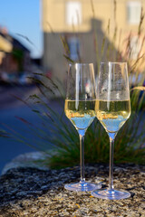 Tasting of premier cru sparkling white wine with bubbles champagne with view on old houses of...