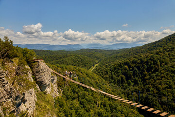 Hanging ladder over a precipice in the mountains. Attraction in the rocks, a walk along the stairs over a deep abyss, copy space.