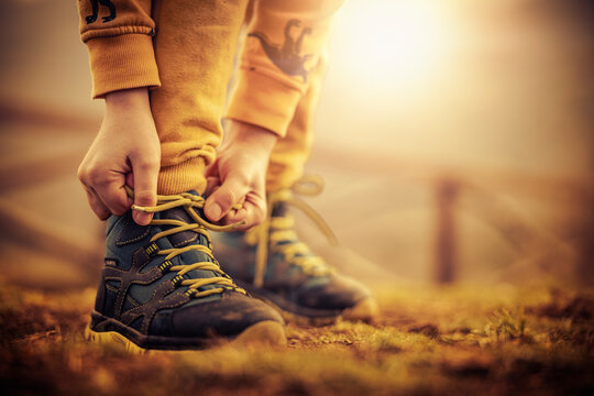 Close up of  child tying sport shoes in nature
