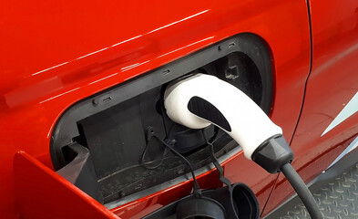 EV car or electric car at charging station with power bank connected. Eco friendly alternative energy concept