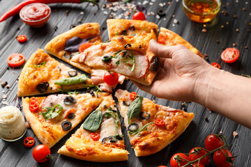 Hands taking pizza slices top view.