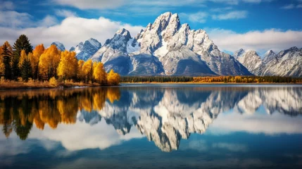 Papier Peint photo Chaîne Teton  a breathtaking image of the Grand Tetons reflected in a glassy alpine lake surrounded by colorful fall foliage 